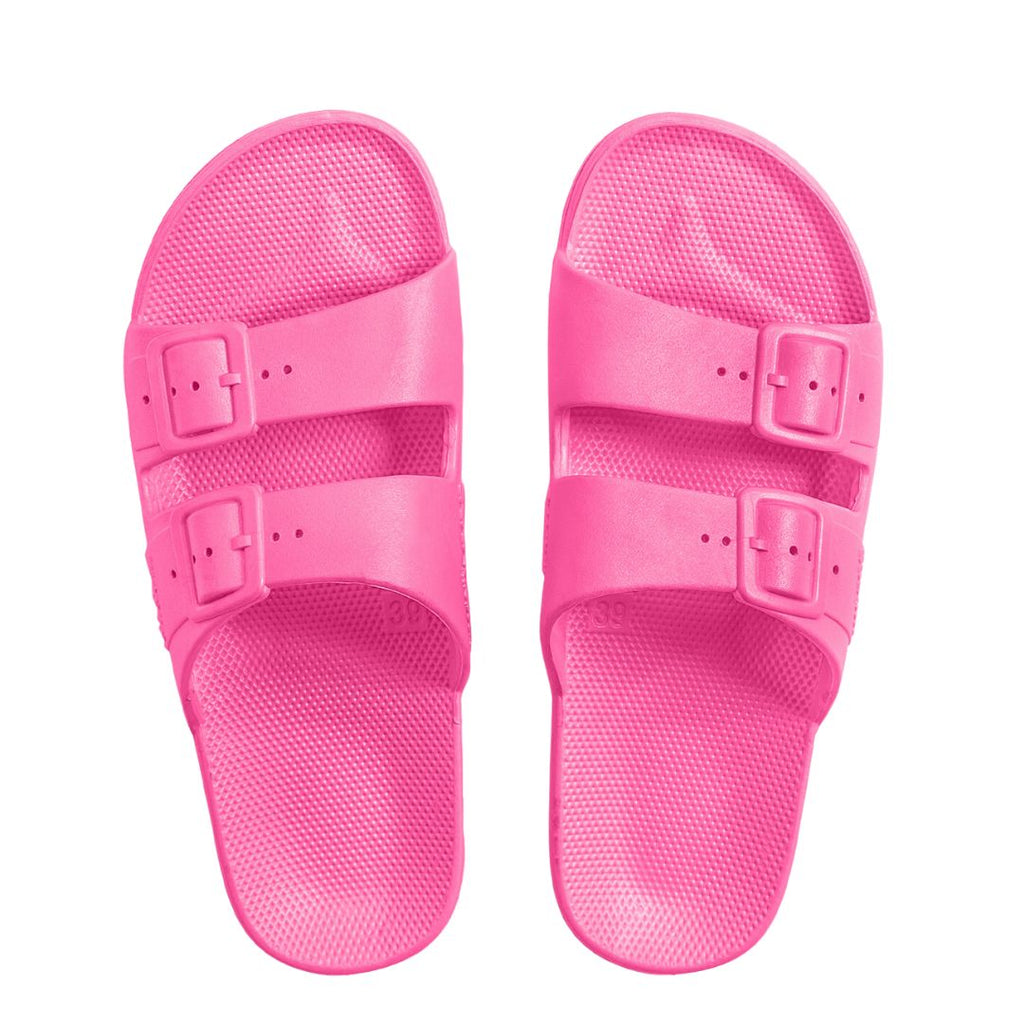 Show your feet some love this summer with the Freedom Moses Glow Pink Neon Slides! Flexible PVC ensures you’ll be moving smoothly and with great grip, while fixed buckles and a supportive footbed